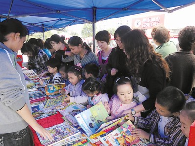 义卖书籍为暖冬添一把火 社区志愿者小摊前吆