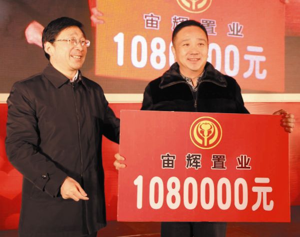 区委书记吉子俊为蝉连首善的爱心大使朱育青颁发证书,首善纪念牌,并