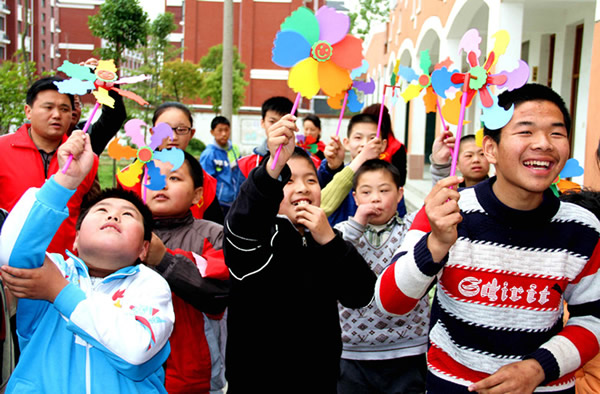 4月25日,仪征市特殊学校,一群在校智障儿童在义工们的帮助下,手持