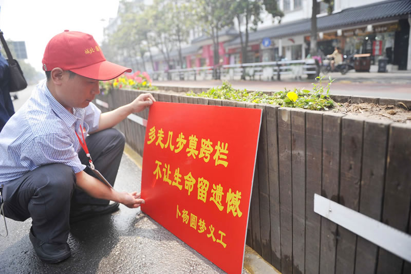 扬州志愿者上街劝阻跨护栏过马路 一个半小时