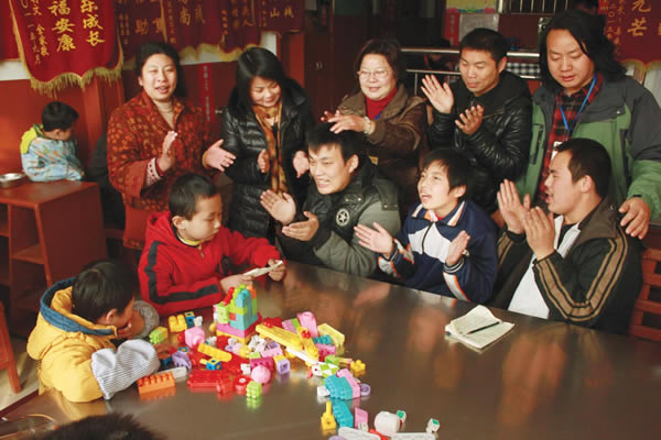 志愿者与智障孩一起唱歌,凌万兵是智障娃眼中的孩子王。董辉 摄 扬州志愿者帮助残疾人上下台阶无障碍旅游。刘江瑞 摄 一支义工队抱团行善,搀扶千名残疾人逛扬州 最美粢饭哥,美在他搀扶残障老人的背影里。 2011年,凌万兵与网友东方等人发起组建扬州志愿者联盟社团,从此,这位粢饭哥做慈善有了明晰的方向和更多支持的力量。 敬老院里的老人,多为残障、卧病在床,或者腿脚不便。对他们来说,外出走走看看,是一件很不容易的事情。凌万兵组织扬州志愿者联盟,先后走进汊河鸣放孝老院、甘